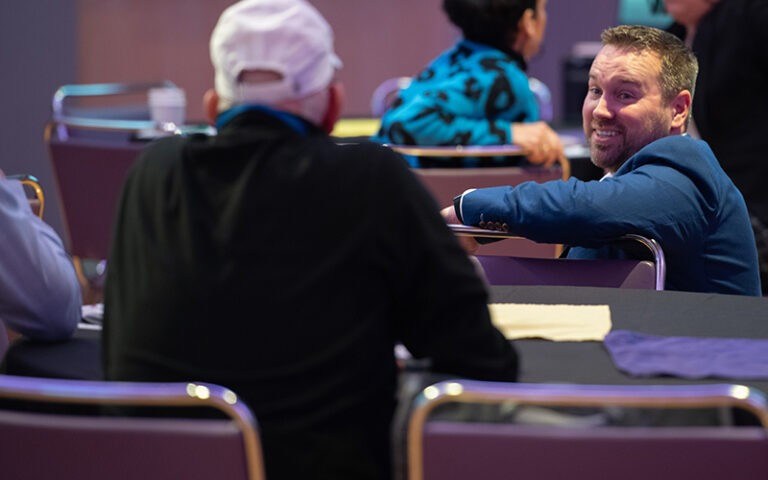Attendees at a Recharge America Symposium talking while seated.